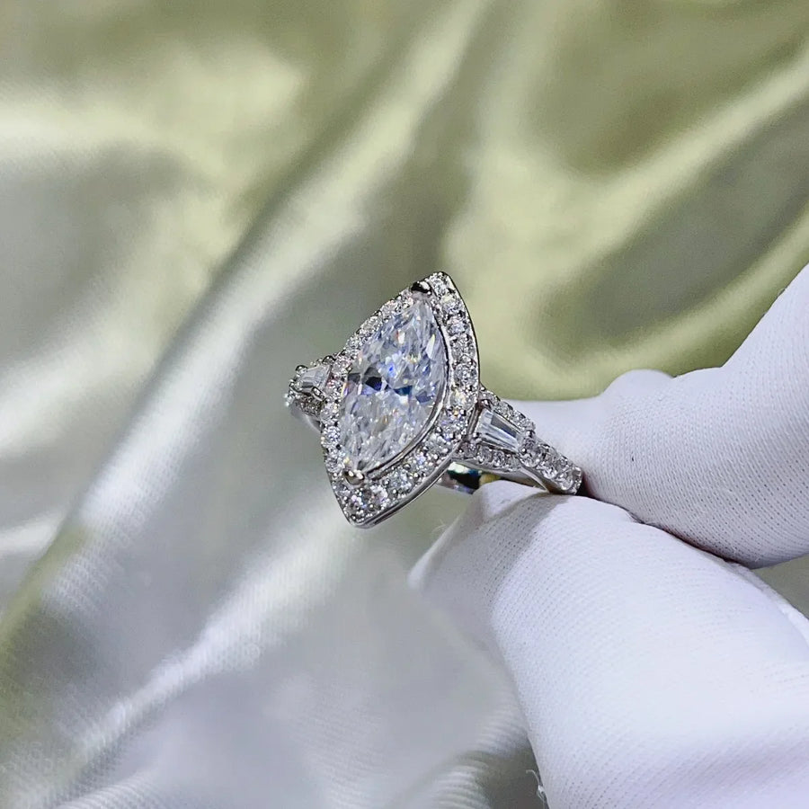 White gold marquise halo moissanite engagement ring with baguette side stones.
