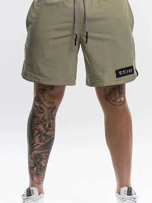 Khaki performance drawstring shorts with black logo patch and white drawstring.