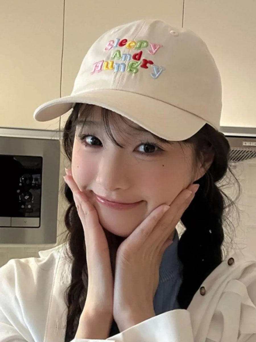 Beige baseball cap with colorful "Sleepy And Hungry" embroidery
