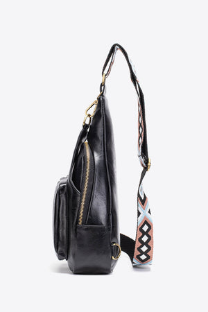 Black textured sling bag with woven strap detail and gold zipper