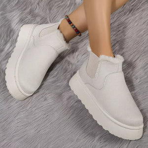 Beige suede round toe platform ankle boots with faux fur trim and elastic side panels.