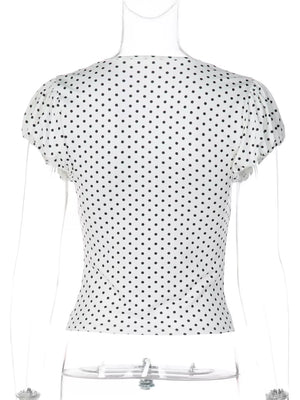 White polka dot ruched t-shirt with short sleeves and a V-neckline.