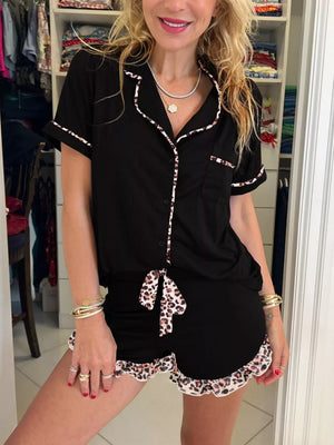 Chic black pajama set with leopard trim shorts and button-up top.