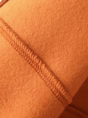 Orange casual zip-up top and wide-leg pants set detail showing textured stitching on soft fabric.