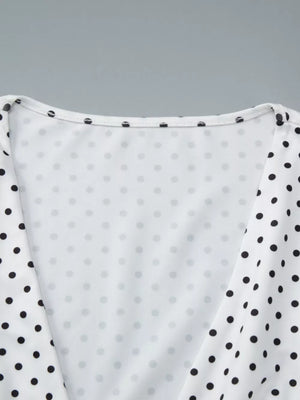 White polka dot ruched t-shirt with a v-neckline and short sleeves.
