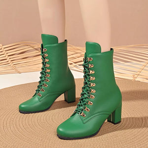 Green lace-up block heel boots with gold eyelets and laces.
