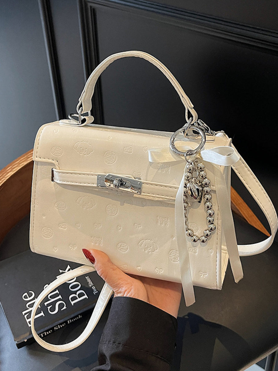 Ivory embossed pu leather mini crossbody bag with dog and heart pattern and charm.