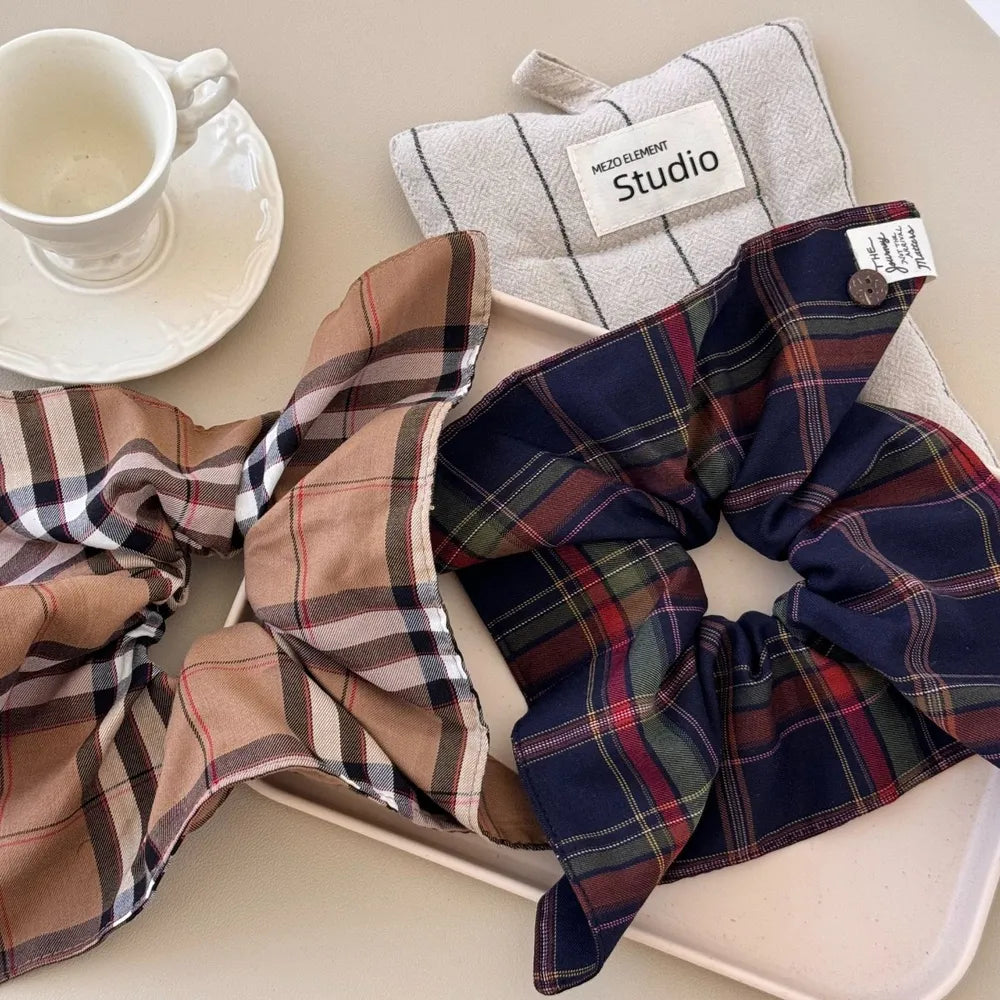 Plaid bow-tie scrunchie with button detail in Indigo and Camel colors.