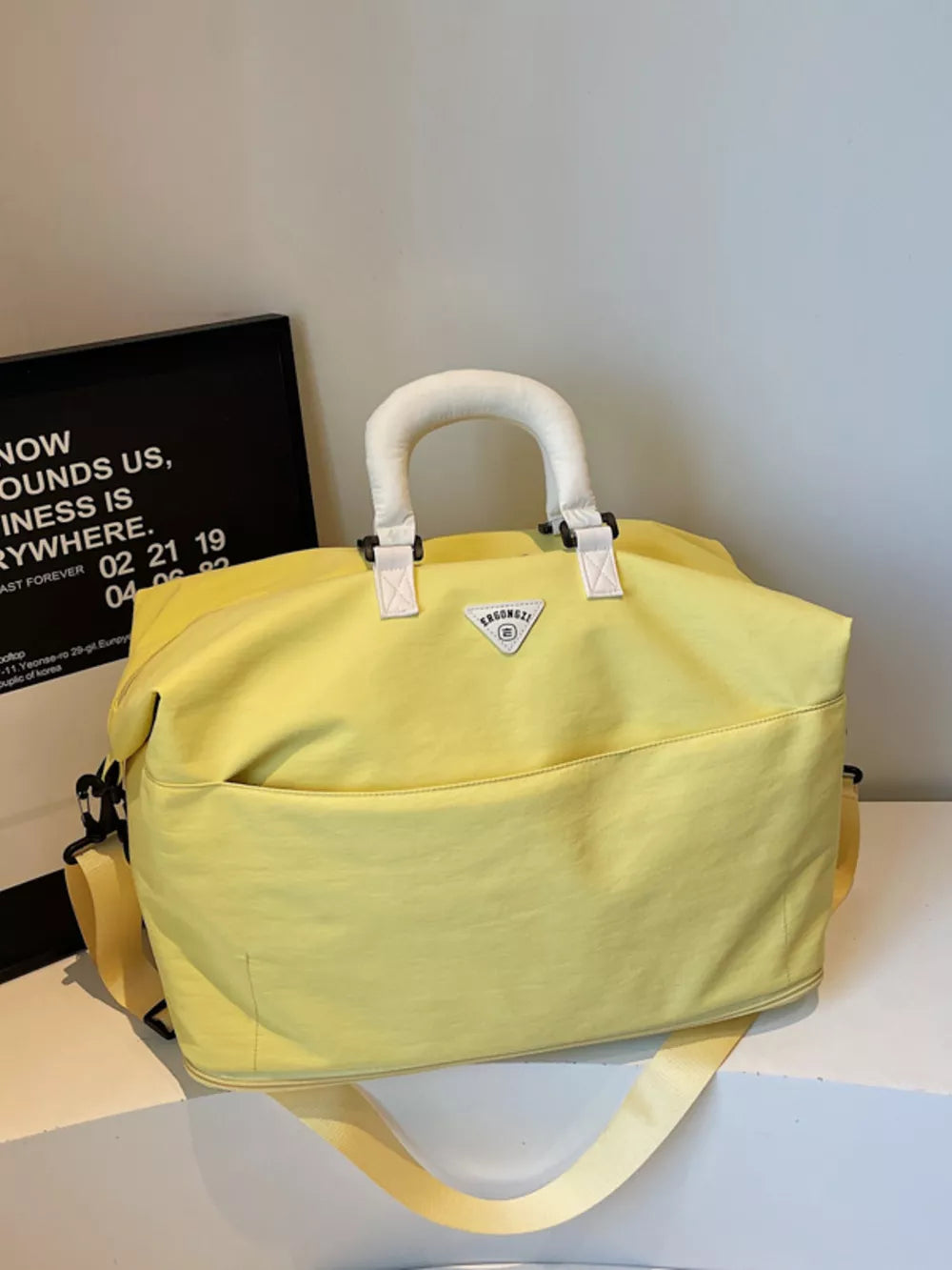 Luxurious yellow Oxford cloth duffel bag with white handles and a front pocket.