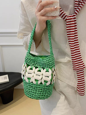 Green woven straw bucket tote with white ring detail and braided strap.