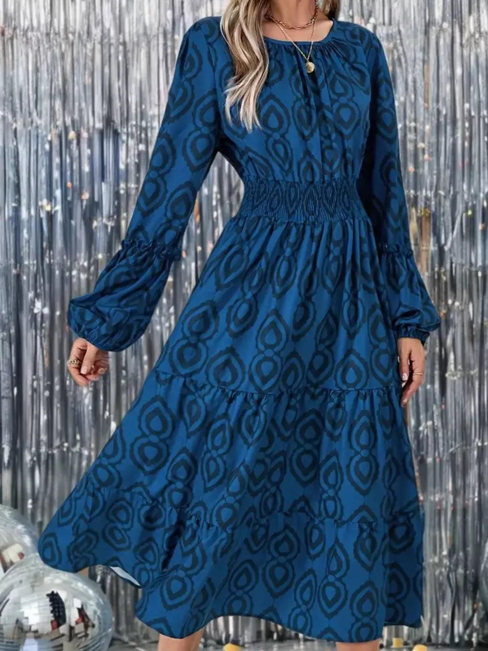 Blue abstract pattern smocked midi dress with balloon sleeves and tiered skirt.