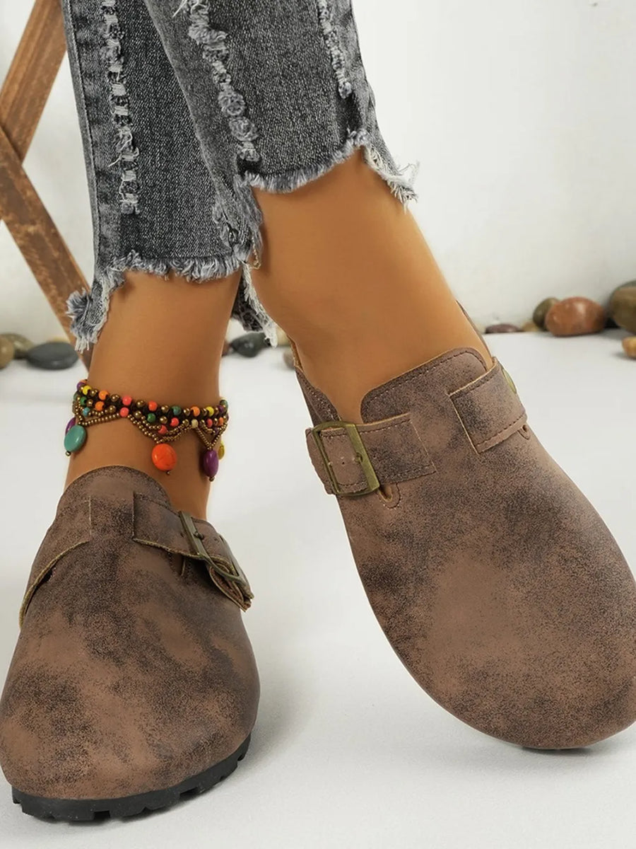 Brown textured suede mules with buckle detail and cork sole.