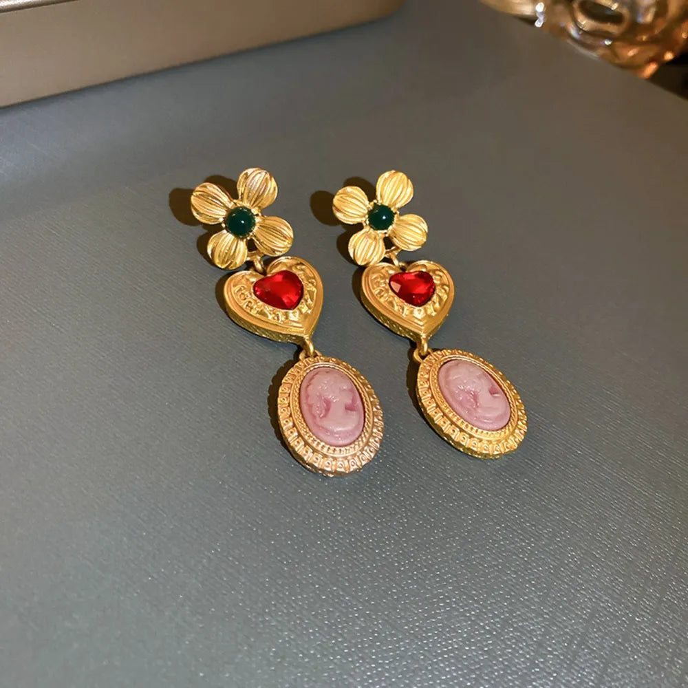 Gold cameo drop earrings with flower and heart details and red and green stones