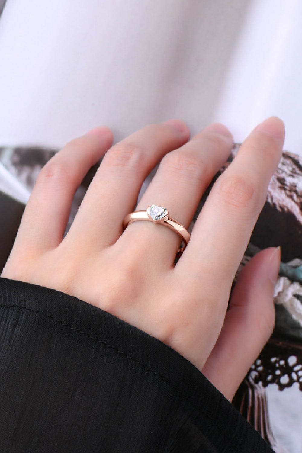 Rose gold ring with a heart-cut moissanite solitaire on a sterling silver band.