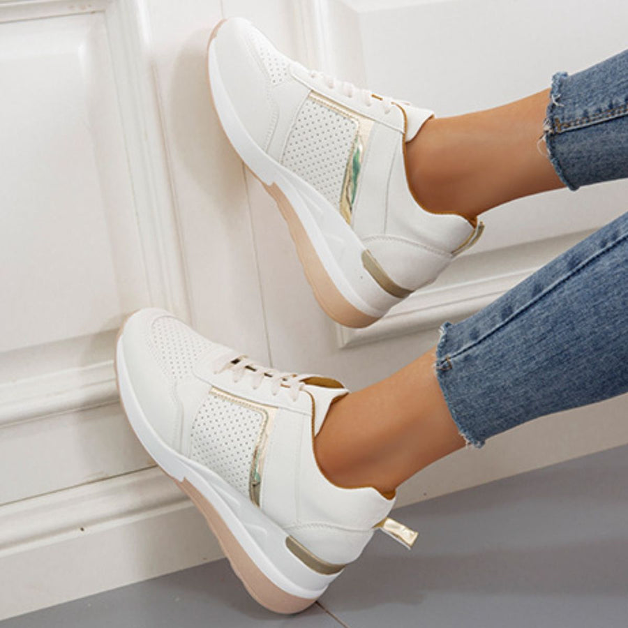 White lace-up wedge sneakers with metallic accents and perforated details.