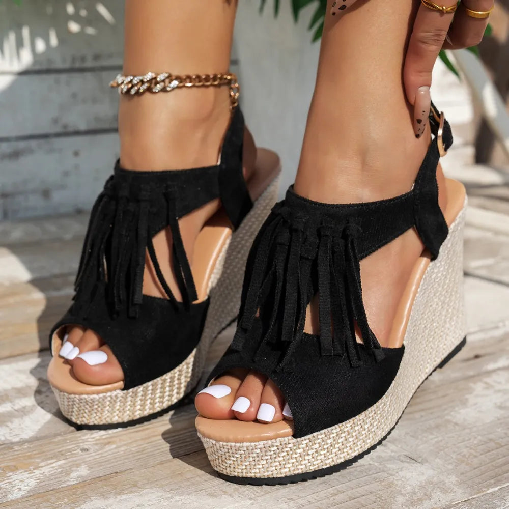 Black suede fringe espadrille wedges with a woven wedge heel.