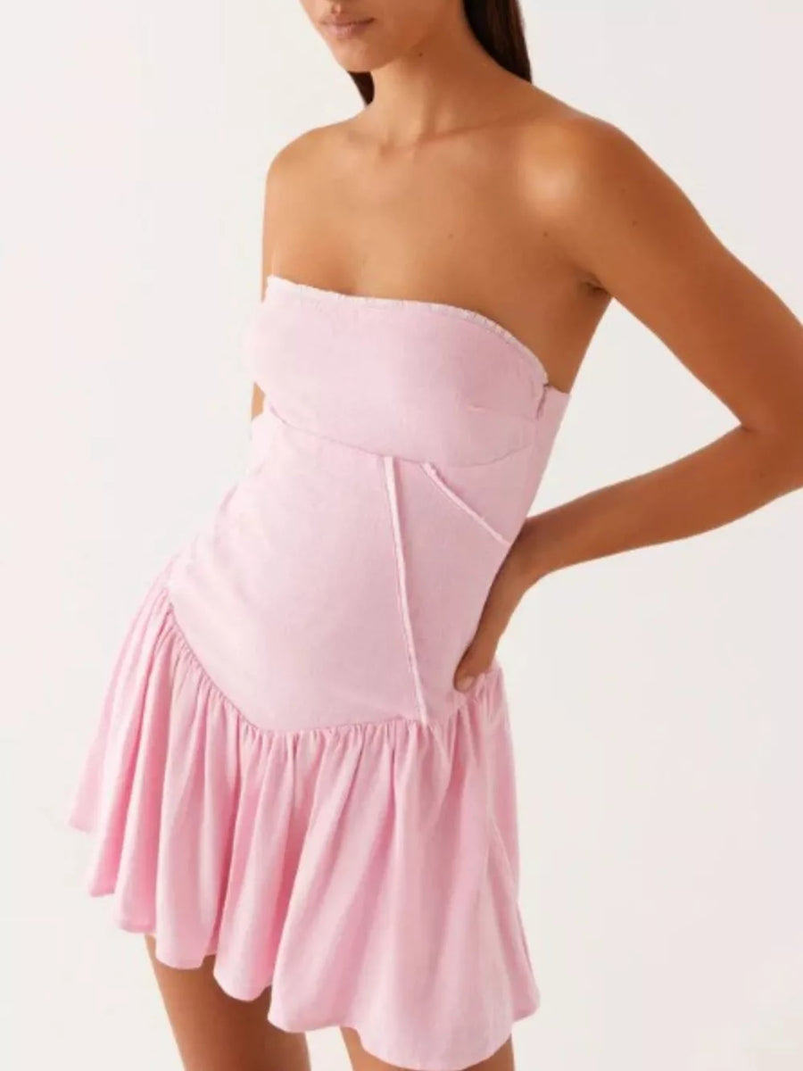 Ruffled tube dress in blush pink with a gathered skirt and contrast stitching.