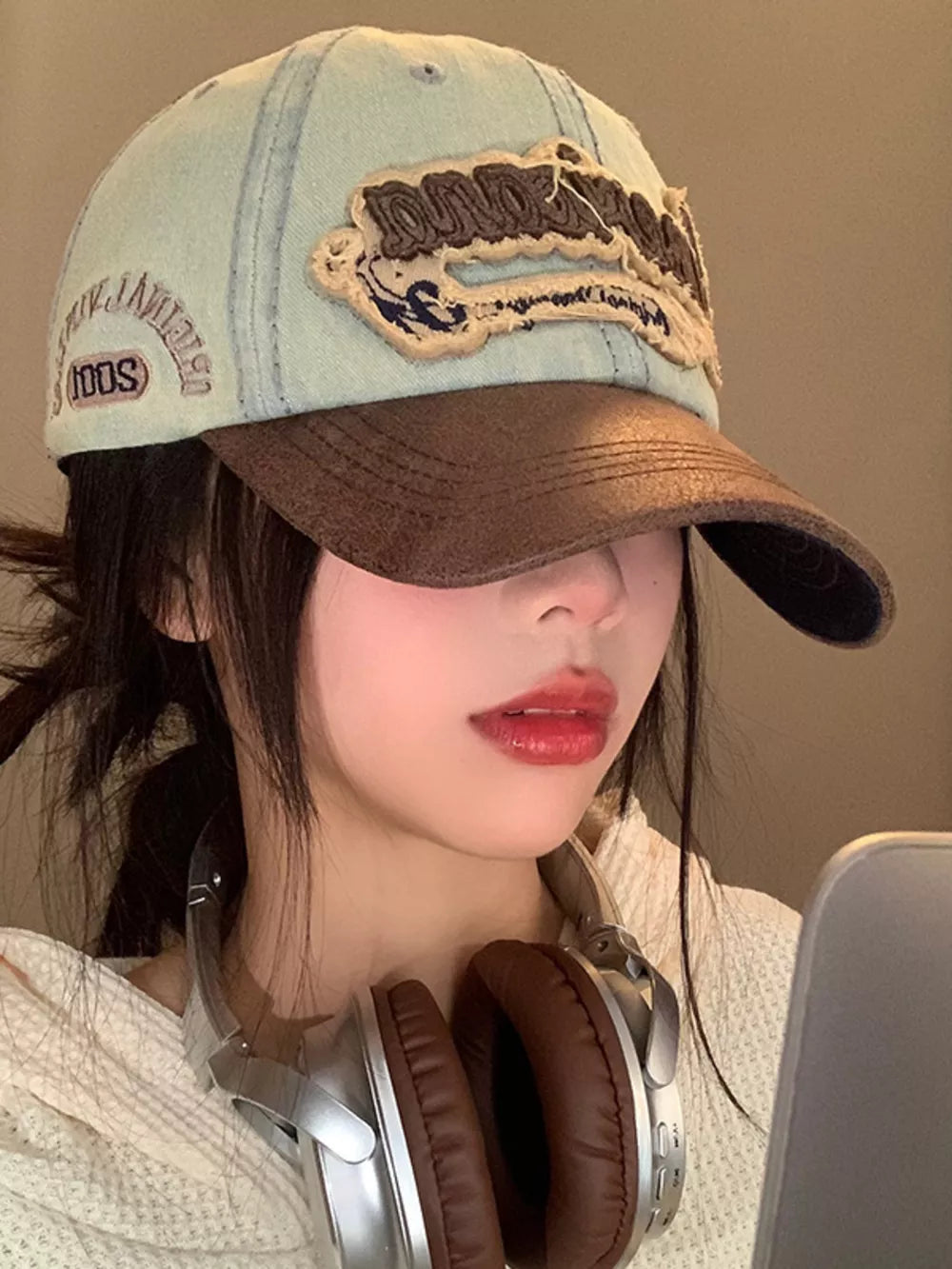 Distressed denim baseball cap in light cowboy blue with embroidered logo and brown brim.