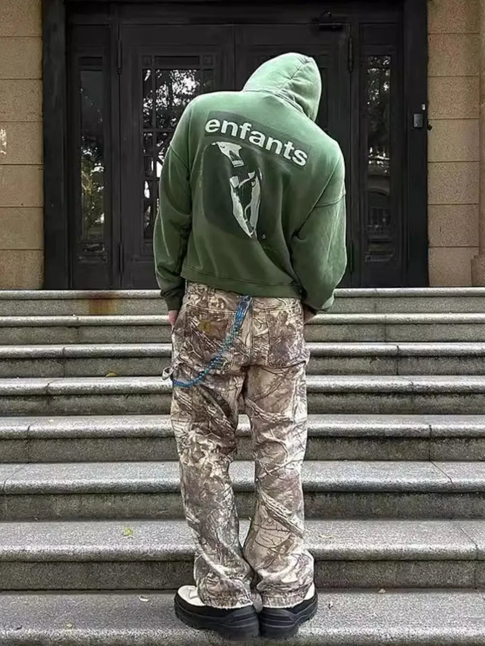 Distressed camo carpenter jeans with blue chain detail and cargo pockets.