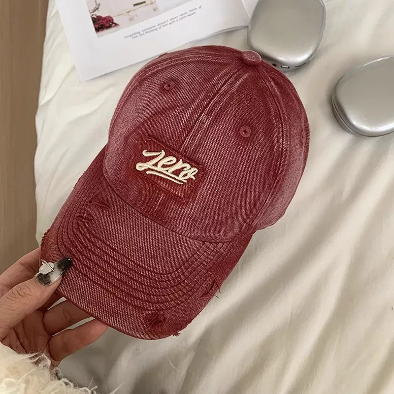 Distressed cotton baseball cap in Deep Red with embroidered "Zero" patch and frayed details.