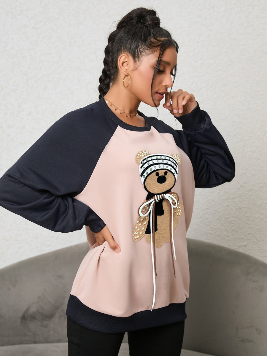 Blush pink raglan sweatshirt with teddy bear appliqué and beaded details.