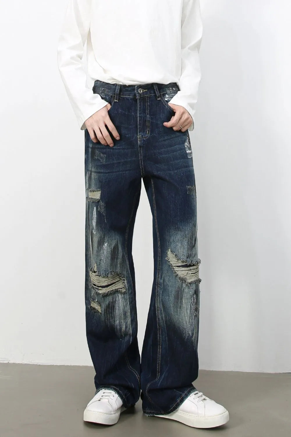 Oversized distressed dark wash denim jeans with wide legs and ripped details.