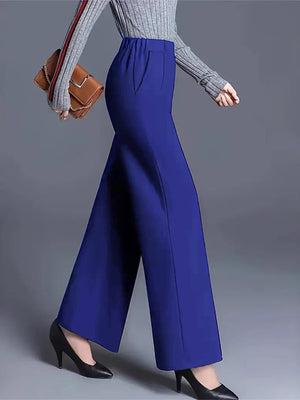 Blue high-waisted wide leg cotton trousers with pockets, styled with a grey sweater and black heels.