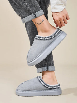 Gray shearling house slippers with embroidered trim and faux fur lining.
