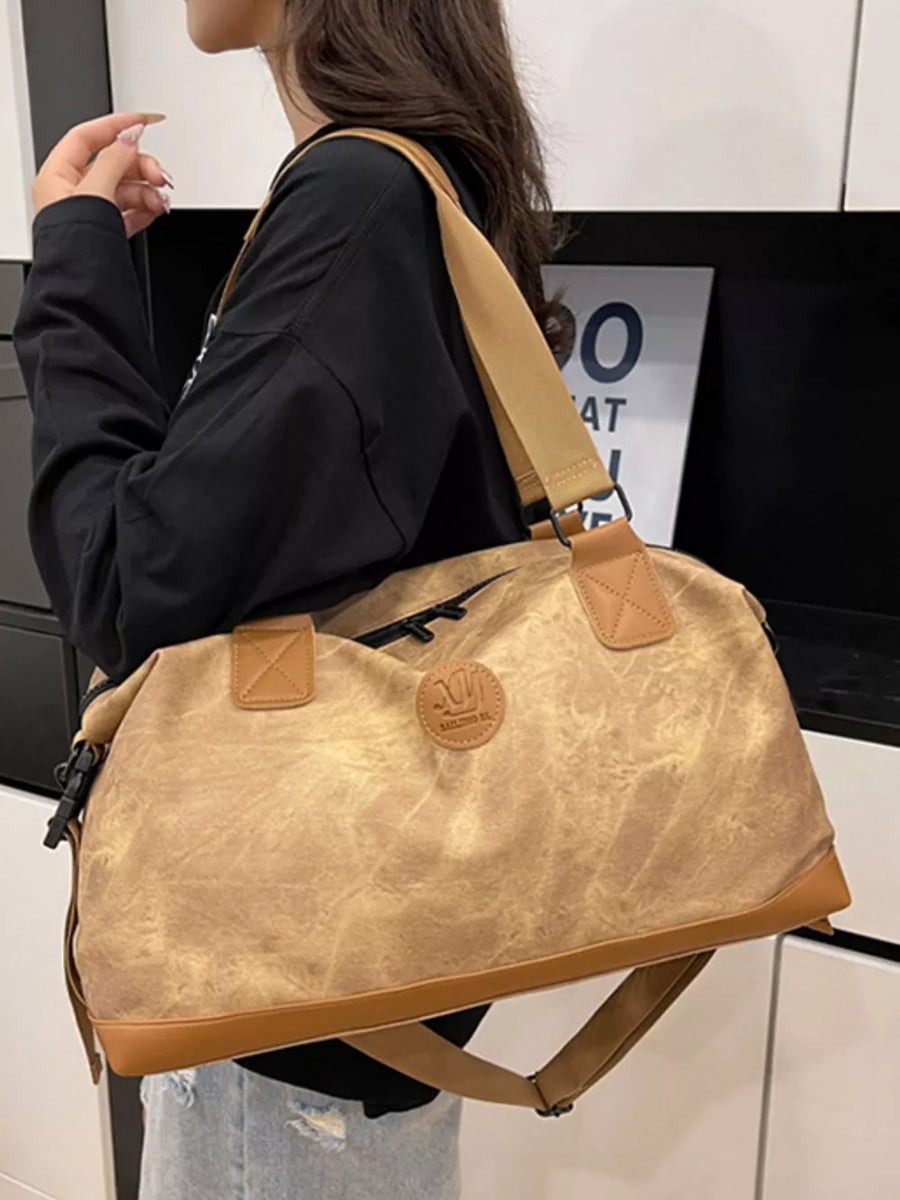 Brown Oxford cloth duffel bag with leather trim and detachable strap.