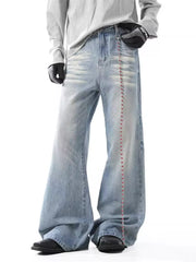 Light wash men's wide-leg jeans with distressed details and a beaded chain accent.