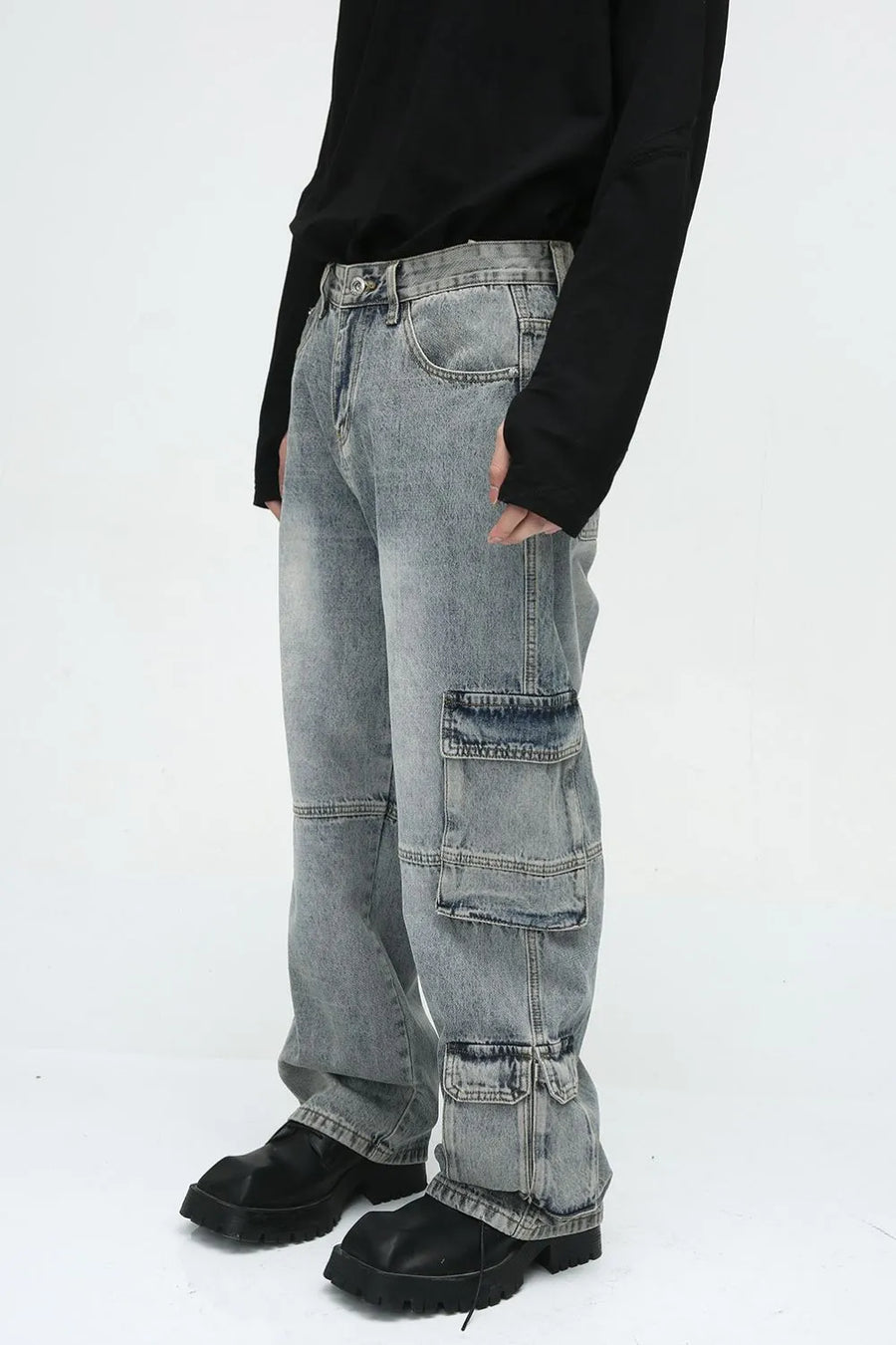 Medium wash denim cargo pants with multiple utility pockets and wide legs.