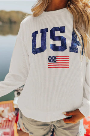 White ribbed knit sweatshirt with blue USA graphic and American flag detail.