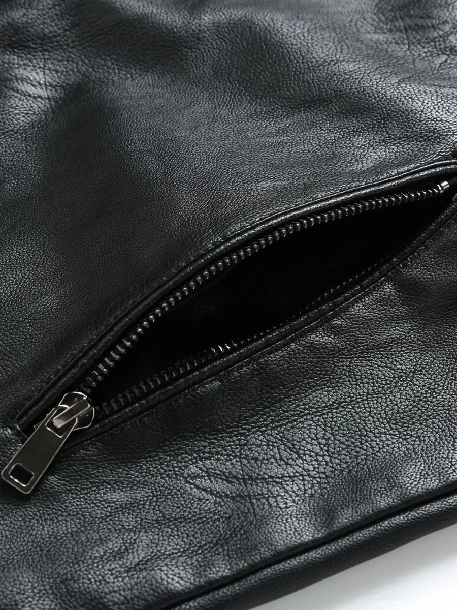 Black plus-size moto jacket detail showing a zippered pocket with silver hardware.