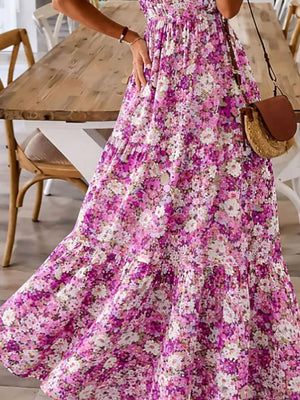 Maxi dress with spaghetti straps and floral print in pink and white, tiered skirt.