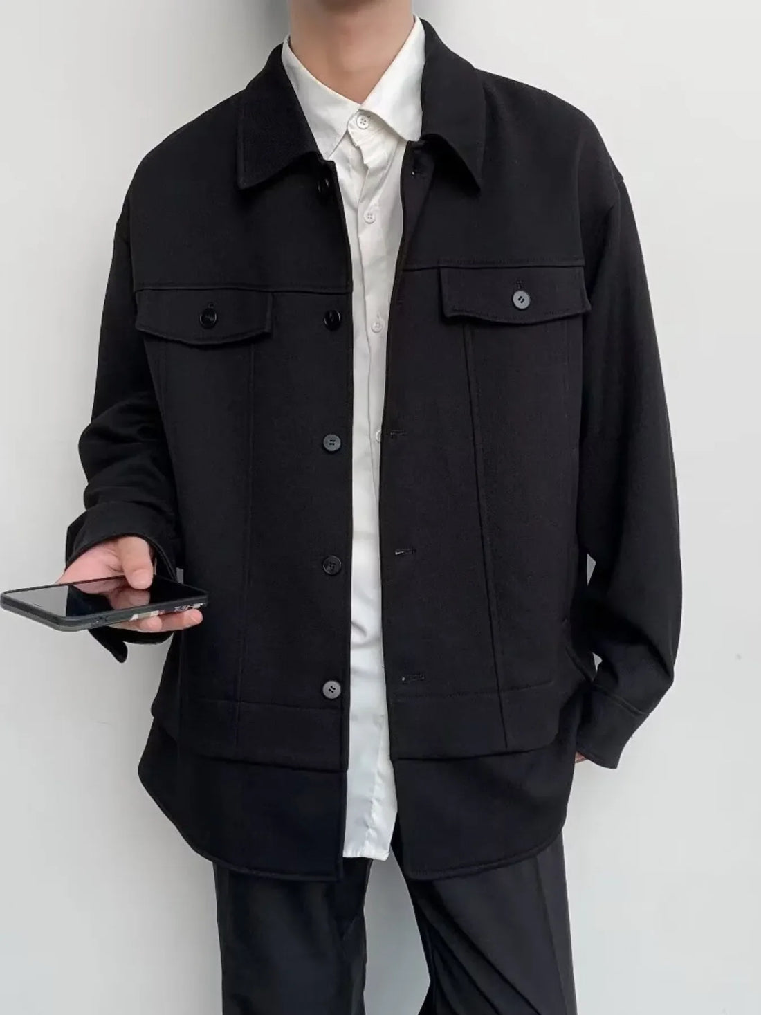 Black oversized button-down jacket with dual chest pockets and button closure.