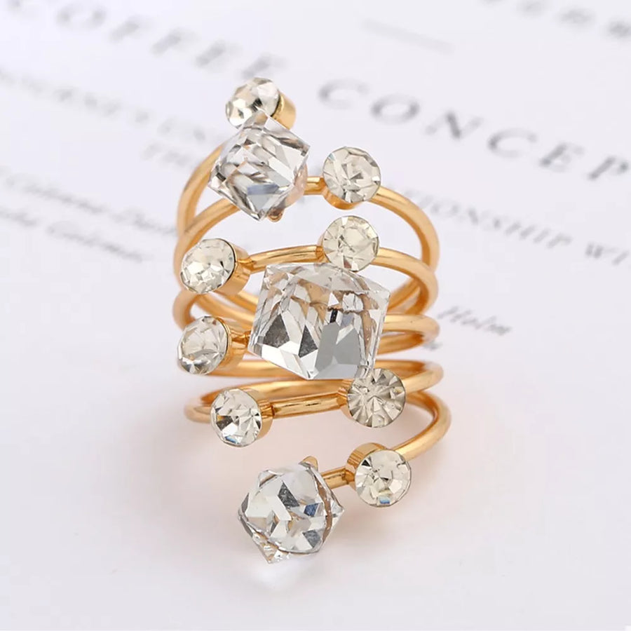 Gold-plated multi-layered ring with clear crystals and square-cut gems.