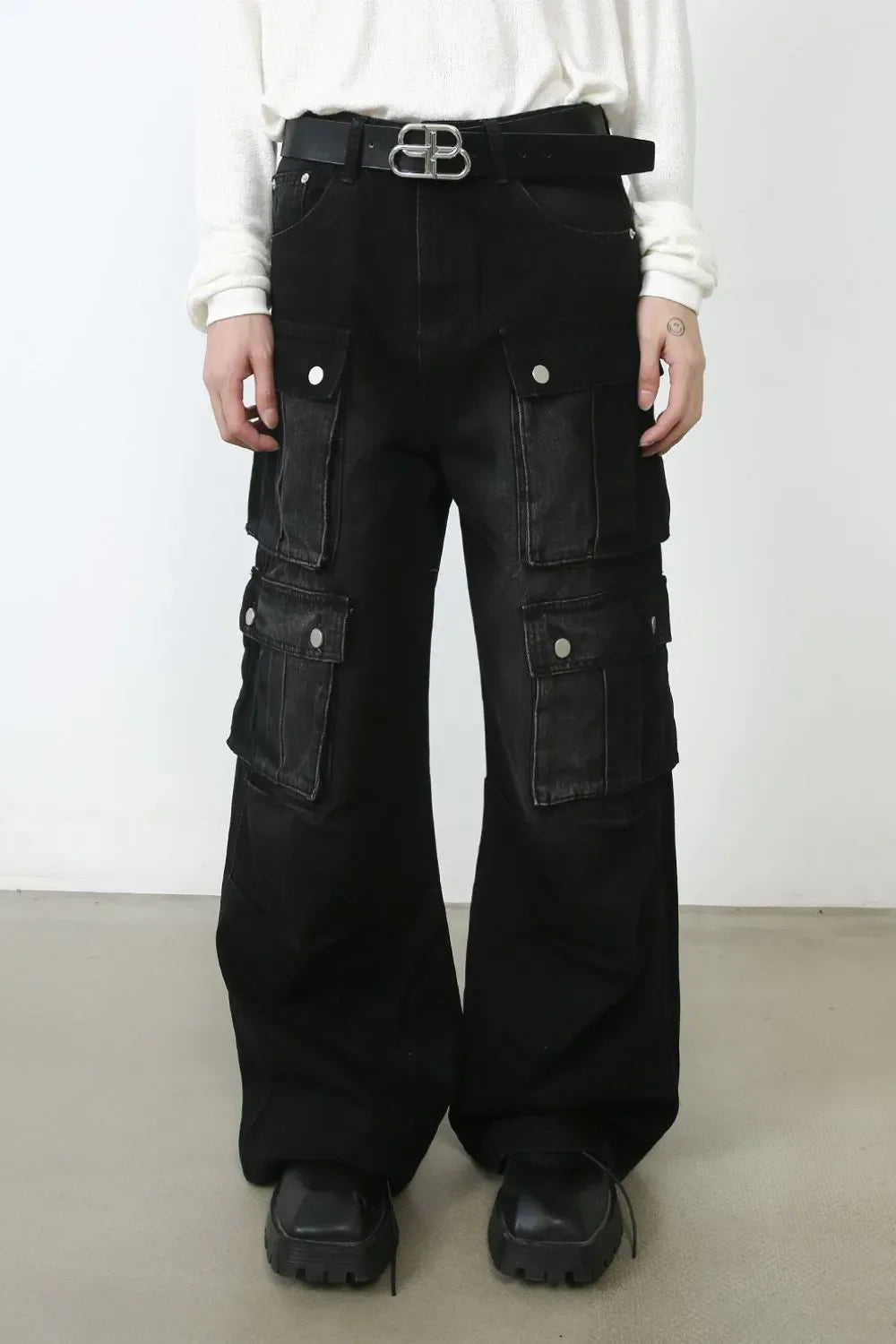 Oversized dark denim cargo pants with multiple pockets and a wide leg.