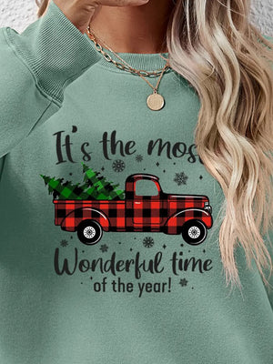 Green crewneck sweatshirt with buffalo plaid truck graphic and holiday text.