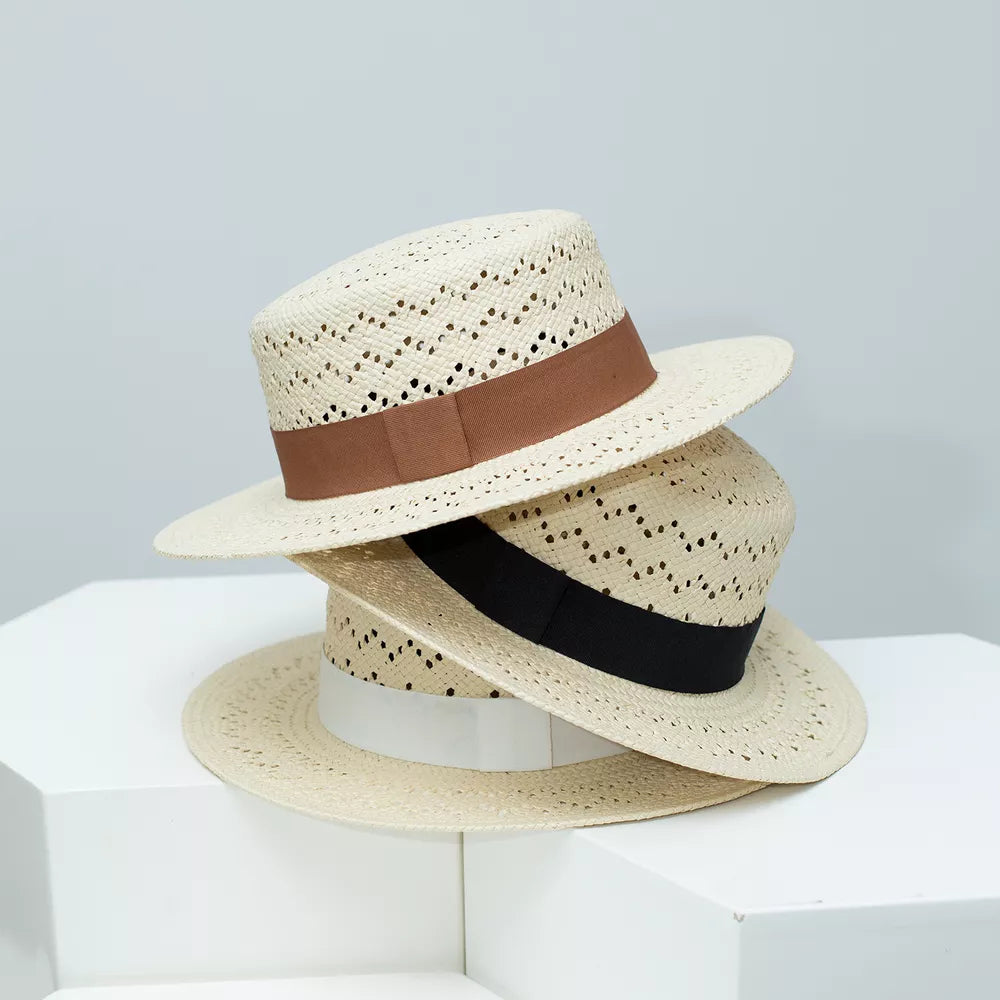 Classic woven straw boater hat with brown, black, and white ribbon detail