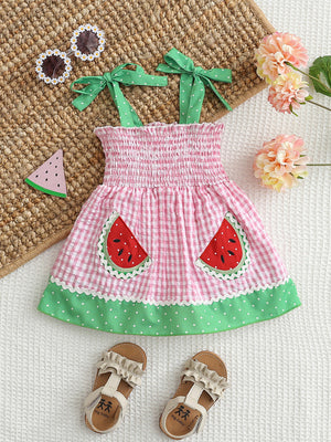 Pink gingham baby dress with smocked bodice, watermelon pockets, and green polka dot trim.