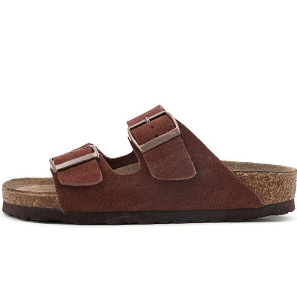 Dark brown suede slide sandals with two adjustable buckles and cork sole.