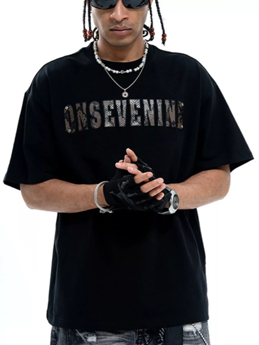 Black cotton oversized t-shirt with a textured logo graphic on the chest.