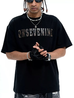 Black cotton oversized t-shirt with a textured logo graphic on the chest.