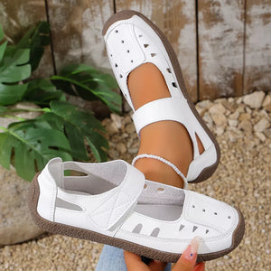 White leather round toe platform flats with cutouts and adjustable strap.