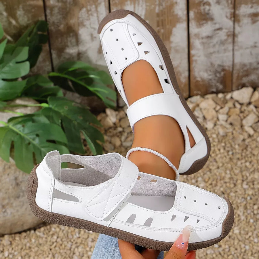White leather round toe platform flats with cutouts and adjustable strap.