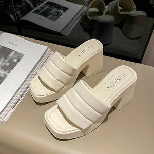 Ivory padded platform mules with block heel and square toe.