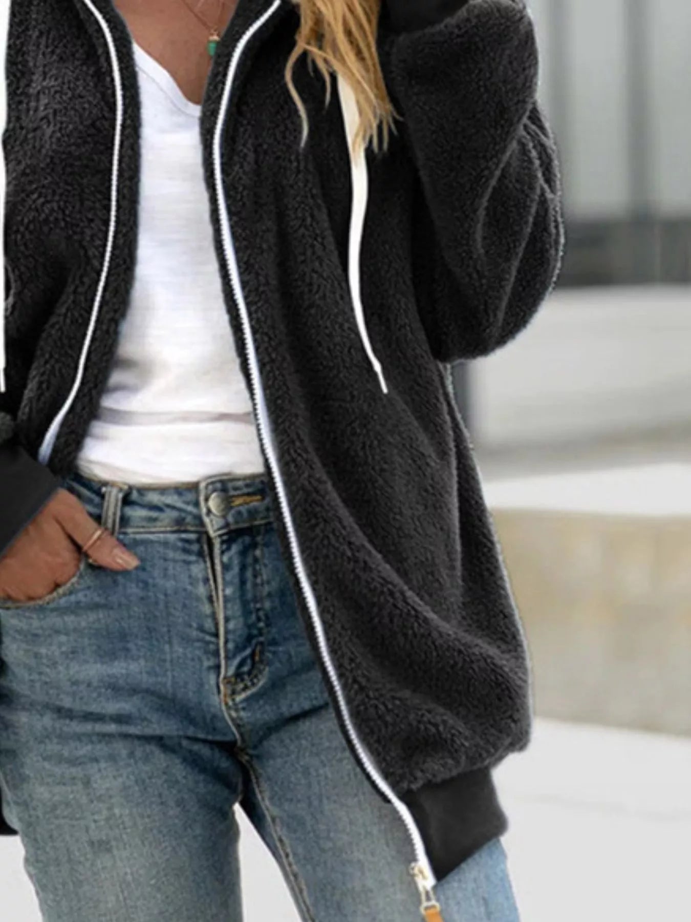 Black cozy fleece zip-up hooded jacket with white zipper and drawstring.