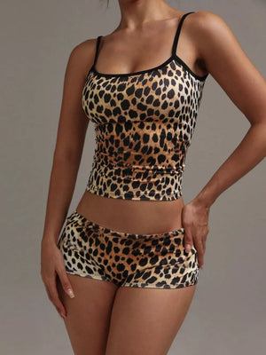 Women's leopard print cami and shorts pajama set with black trim.