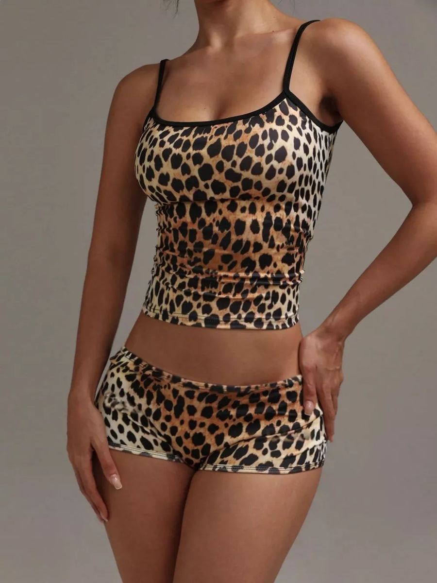 Women's leopard print cami and shorts pajama set with black trim.
