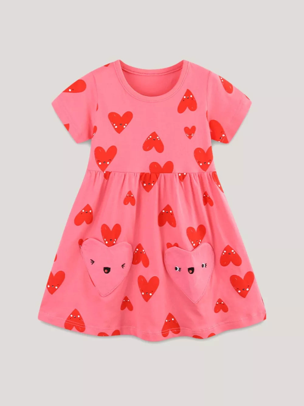 Pink cotton baby dress with red heart print and heart-shaped pockets.